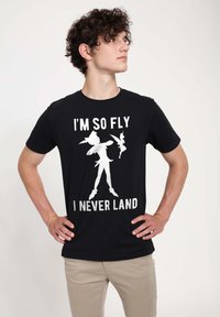 Zwarte katoen T-shirt met witte grafische tekst: "IK BEN ZO VLEUGELIG DAT IK NOOIT LAND," met silhouetten van een personage en een fee.