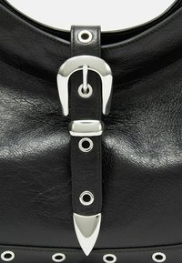 Borsa a tracolla in pelle nera texture con una grande fibbia metallica, accentuazioni argentate e occhielli decorativi lungo il bordo inferiore.