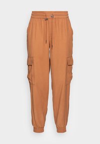 Pantalones cargo de un color marrón anaranjado cálido, fabricados con una tela suave. Cuentan con una cinturilla elástica y puños, además de bolsillos laterales.