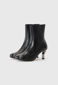 Black leather ankle boots with a sleek design, rounded toe, and metallic heel featuring geometric cutouts. Smooth texture and minimalist style.