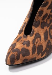 Leopardenmuster Stiefelette, aus braunem Wildleder, mit spitzer Zehenform und Ausschnittdesign, mit dunklen Braun- und Beigeakzenten.