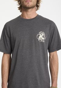 Czarny, ciemnoszary t-shirt bawełniany z krótkim rękawem, z białym nadrukiem graficznym przedstawiającym projekt sklepu z butelkami po lewej stronie klatki piersiowej.