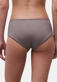 Braune Hipster-Unterwäsche mit glatter Textur, figurbetontem Design und nahtlosen Kanten. Keine sichtbaren Muster oder Hardware-Details.