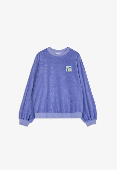 Lavender lange mouwen sweatshirt met ribbelboorden aan de mouwen en onderkant, met een kleine kleurrijke vierkante grafiek met cirkels en dambordpatronen op de borst.