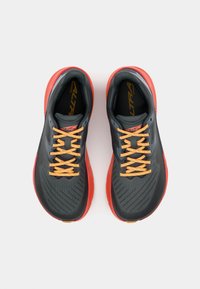 Baskets de course noires et grises avec des lacets orange, dessus texturé et semelles rouges. Présente un design épuré pour la performance.