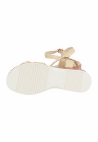 Sandalo beige con cinturino, suola in gomma bianca texture, chiusura con fibbia e tacco piatto. Presenta cinturini diagonali e una superficie liscia.