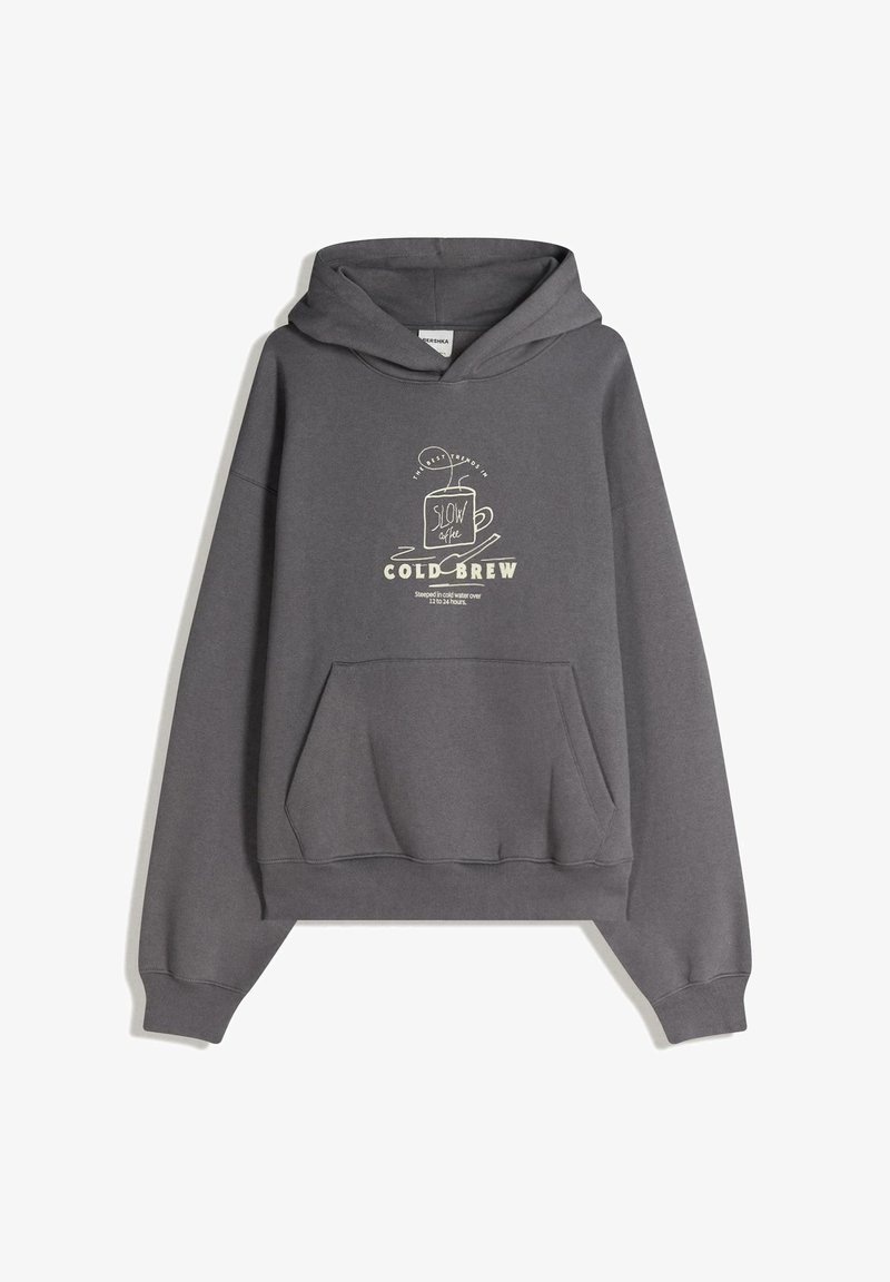 Szürke kapucnis pulóver puha anyagból. Elöl egy zseb, krémszínű, kávé témájú nyomtatott grafikákkal díszítve.