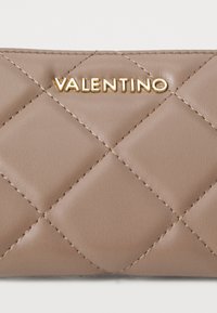 Nudus odos piniginė su rausvos spalvos siūlais, pasižyminti auksiniu "Valentino" logotipu, ryškiomis siūlėmis ir tekstūruotomis paviršiaus raštais.