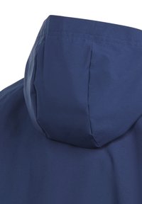 Mörkblå hujacka med slät yta, med en strukturerad huva och minimalistisk design. Tyget verkar vara lätt och väderresistent.