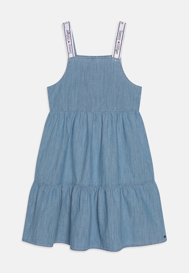 Vestido de denim azul claro con tirantes ajustables, falda acampanada de volantes y detalles del logo en los tirantes. Diseño A-line sencillo, estilo casual.