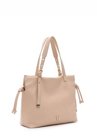 Jasno beżowa skórzana torba tote z podwójnymi uchwytami, bocznymi zawiązaniami, złotym okuciem oraz detalem logo z przodu. Gładka faktura, usztywniony kształt.