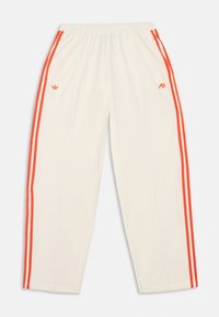 Λευκό παντελόνι φόρμας με ελαστική μέση, με πορτοκαλί τριπλές ρίγες κατά μήκος των πλευρών και μικρά πορτοκαλί λογότυπα στο μπροστινό μέρος.