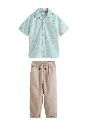 Camicia azzurro chiaro a maniche corte con bottoni, linee sottili scure e motivo floreale astratto, abbinata a pantaloni beige con coulisse e orli risvoltati.