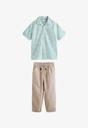Light blue short-sleeve button-up shirt with thin dark lines and abstract floral pattern, paired with beige drawstring pants with cuffed hems.