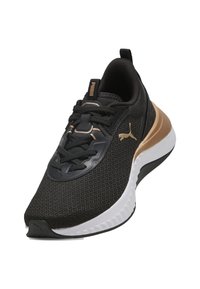 Scarpa sportiva nera con tomaia in mesh, dettagli dorati, lacci e suola spessa bianca e nera. Logo Puma di lato e sulla linguetta.