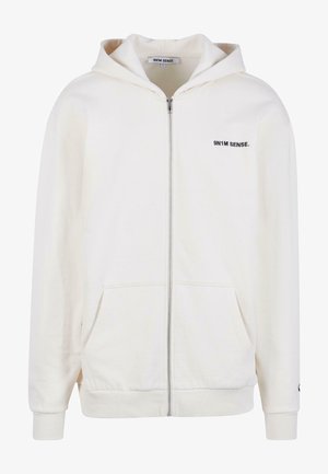 Krēmveida kapucīna džemperis, izgatavots no mīksta auduma, ar odere kapuci, priekšējām kabatām un melnu "9N1M SENSE" tekstu uz krūtīm.