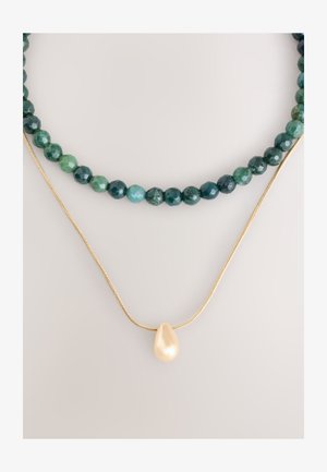 Mehrsträngige Halskette mit dunkelgrünen und blaugrünen facettierten Perlen, mit einer goldenen Kette und einem glänzenden tropfenförmigen Perlenanhänger.
