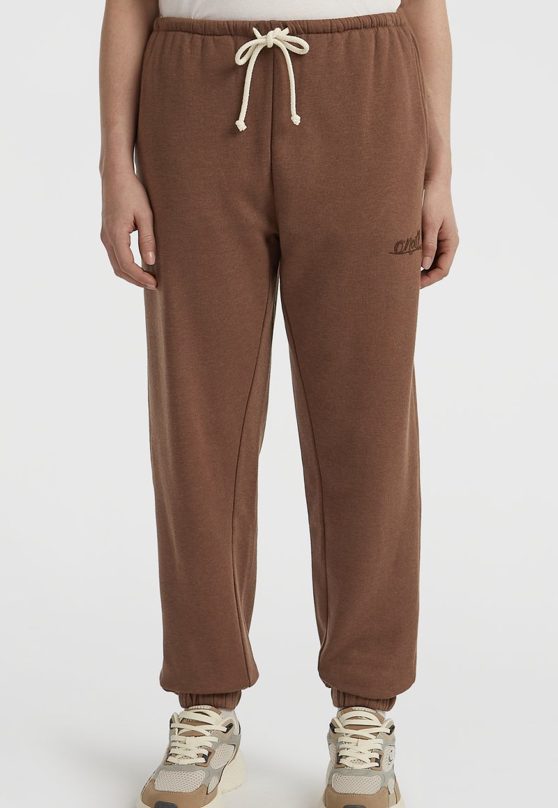 Pantalones de chándal marrones de tela suave con cintura elástica, cordón y tobillos ajustados. Presenta un sutil detalle del logo en el lateral.