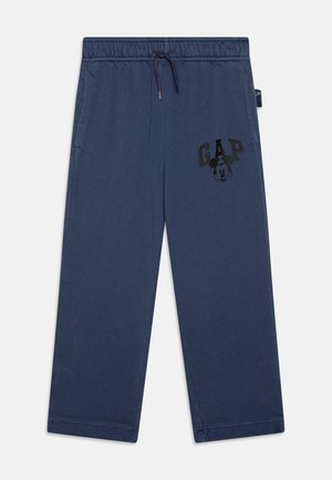 Marineblauwe sweatpants van een katoenmix, met een elastische tailleband met trekkoord, zijzakken en een zwart "GAP" logo met een cartoon gezicht.