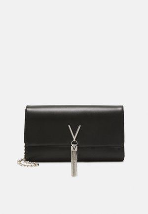 Pochette in pelle nera con chiusura a V argentata e nappina a catena, dotata di una corta tracolla a catena argentata su sfondo semplice.