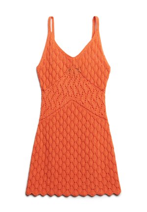 Oranje gebreide jurk met een V-hals, dunne bandjes en een gestructureerd ruitpatroon. Een golvende zoom voegt detail toe aan het ontwerp.