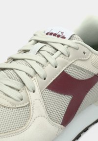 Baskets beige clair en mesh et suède. Comprend un logo bordeaux et des accents assortis, des lacets plats et une semelle blanche.