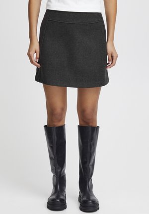 Dark gray fabric A-line skirt with a smooth texture, featuring a mid-rise waist and minimal stitching detail. Paired with black knee-high boots.