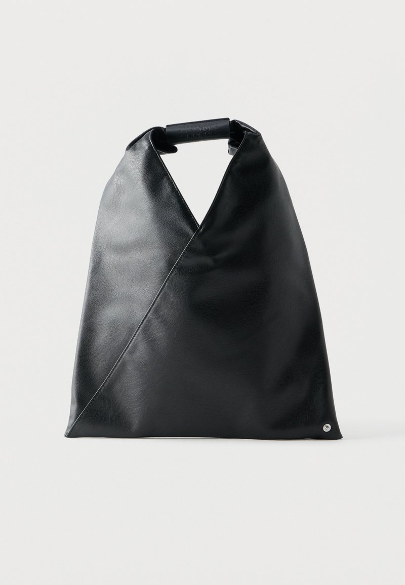 Geantă tote triunghiulară neagră din piele, cu mâner pliat înfășurat în piele asortată, pe un fundal simplu, deschis la culoare.