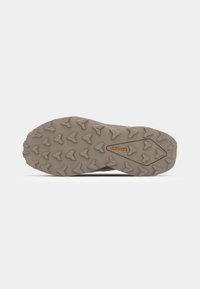 Semelle de chaussure de trail avec une surface en caoutchouc marron rugueux et texturé, dotée de crampons multidirectionnels pour une adhérence optimale. Logo Continental visible.