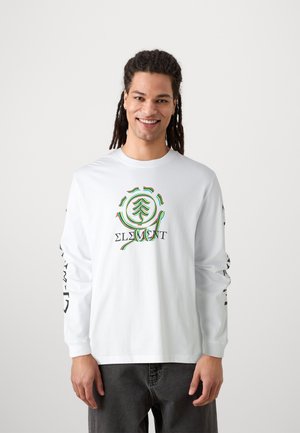 Witte langwerpige T-shirt met lange mouwen met een grafische print van een boomontwerp in groen en meerdere kleuren. Heeft zwarte tekst langs de mouwen. Gemaakt van zachte katoen.