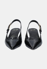 Zapatos slingback de charol negro con punta afilada, textura de reptil en relieve y un acento de hebilla en tono dorado en la correa del tobillo.