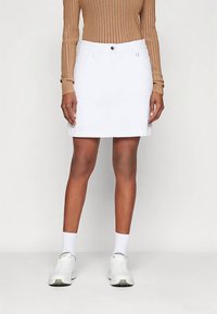 Valkoinen farkkuhame suoralla leikkauksella, viisi taskua ja etupuoli napituksella. Yhdistetty istuvaan ruskeaan ribbineulottuun pitkähihainen toppiin.