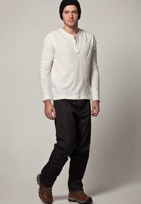 Άσπρο μακρυμάνικο πουκάμισο Henley, μαύρο ελαφρύ παντελόνι, καφέ μποτάκια με κορδόνια και μαύρο πλεκτό σκουφί, με άνετη εφαρμογή και απλό σχέδιο.