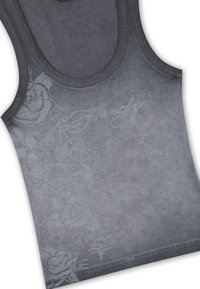 Débardeur gris sans manches avec des motifs floraux subtils et des croix, ainsi qu'un texte cursif discret sur la poitrine et le côté inférieur.
