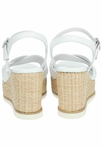 Sandali wedge bianchi in pelle con texture naturale intrecciata sulla base, cinturino alla caviglia regolabile e design con tacco arrotondato.