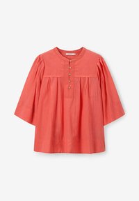 Blouse en coton corail avec un col rond, des manches bouffantes trois-quarts et une patte de boutonnage à cinq boutons, présentant de légères plis sous la poitrine.