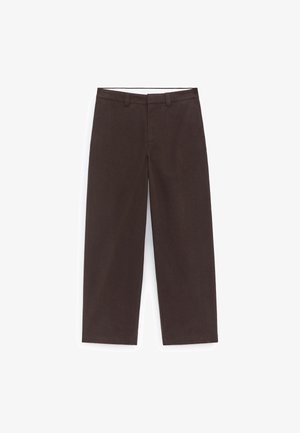 Brązowe spodnie o szerokich nogawkach z gładką fakturą, wyposażone w klasyczny pas z szlufkami na pasek, zaprojektowane dla swobodnego dopasowania.