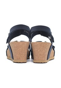 Sandali wedge blu navy con piattaforma in sughero. Design con apertura sul retro, dotati di cinturini regolabili e suola in gomma testurizzata per migliorare la trazione.