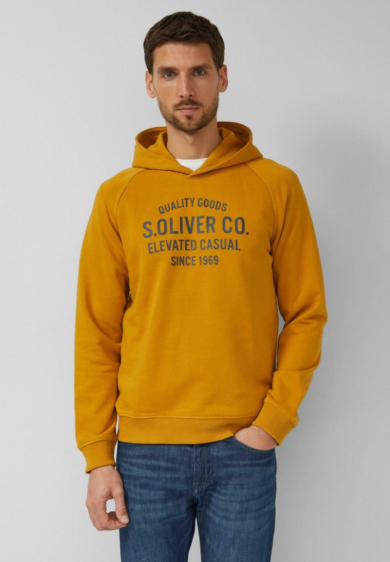 Felpa con cappuccio giallo senape con stampa scura con scritto "S. OLIVER CO." e "QUALITY GOODS." Presenta una tasca a marsupio e polsini a costine.