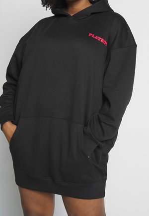 Schwarzes Hoodie-Kleid mit einer Fronttasche und einem pinkfarbenen "PLAYBOY"-Logo auf der linken Brustseite. Weicher Stoff, lockere Passform und lange Ärmel.