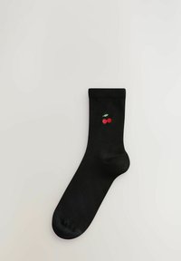 Svart bomullssocka med ribbad manschett och en broderad körsbärsdesign i rött och grönt nära vristen. Slät textur med medellång längd.