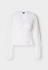 Λευκή μπλούζα με μακριά μανίκια, με σούρες στο ύφασμα, κουμπιά μπροστά, στρογγυλή λαιμόκοψη και ελαφρώς φουσκωτούς ώμους.