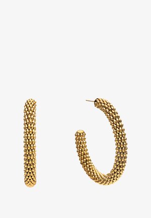 Złote kolczyki koła o teksturowanym wzorze, zawierające szereg małych, zaokrąglonych kształtów. Powierzchnia jest błyszcząca, co dodaje głębi wizualnej.