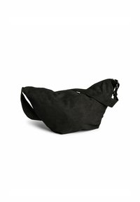 Borsa in suede nera con una forma triangolare unica, tracolla regolabile e una superficie morbida e testurizzata, con un design minimalista privo di hardware.