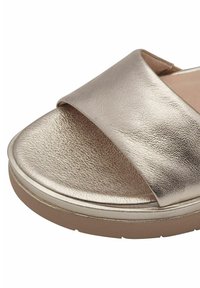 Sandale à glissière en bronze métallisé avec une large sangle, dessus en cuir texturé, semelle intérieure rembourrée et semelle épaisse de couleur claire.