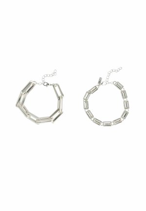 Two silver bracelets: left is an angular chain with elongated links; right features rectangular links with connectors, both finished with adjustable clasps.
