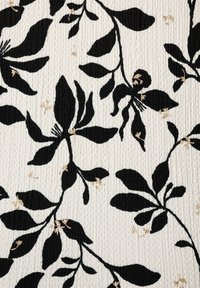 Tissu présentant une base blanche avec une surface texturée, ornée de motifs floraux noirs et d'accents dorés pour un détail supplémentaire.
