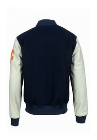 Námořnická vlněná varsity bunda s krémovými koženými rukávy. Obsahuje žebrované manžety a lem, oranžovou vyšívanou písmeno nášivku na levém rukávu.