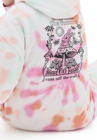 Hoodie tie-dye avec un dessin au trait noir d'un lapin sur un champignon, des fleurs, des papillons, le soleil et le texte « Vous n'êtes jamais trop loin de l'avenir. »