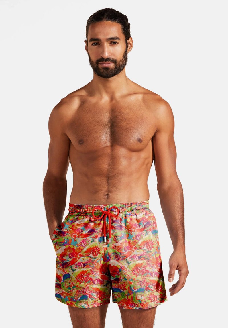 Costume da bagno con un vivace motivo floreale in rosso, rosa e verde. Caratterizzato da un elastico in vita, cordino e tasche laterali.